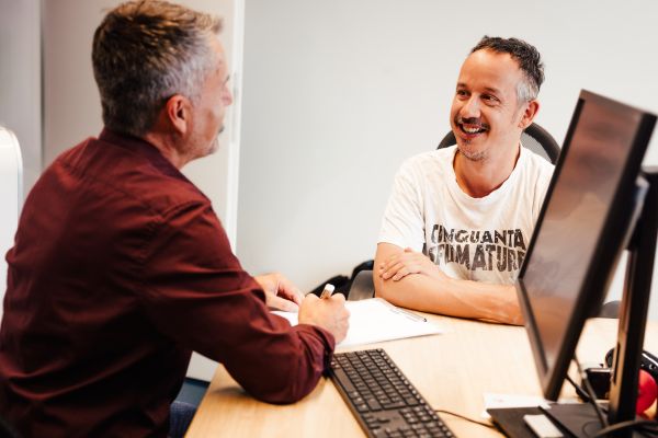 Teilnehmer und Jobcoach im Beratungsgespräch in einem Büro.